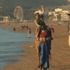 Wycieczka na wielbłądach po plaży, jak z filmu all inclusive. W tle wesołe miasteczko i tłum ludzi.