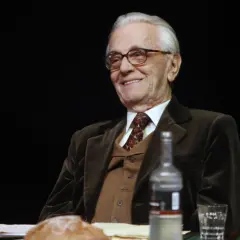 Uśmiechnięty Andrzej Łapicki w eleganckim garniturze, wspominający swoje filmy.