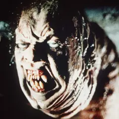 Przerażająca twarz potwora z zębami jak sztylety, w stylu found footage horror.