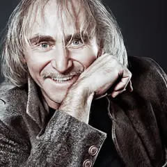 Uśmiechnięty Jerzy Kryszak, znany z wielu ról filmowych, z charakterystyczną fryzurą i wąsami.