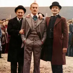 Trzech mężczyzn w melonikach i eleganckich strojach, jak z najlepsze filmy ranking. W tle tłum ludzi.