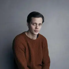 Bill Skarsgård w rudym swetrze, zastanawia się, w jakich filmach grał.