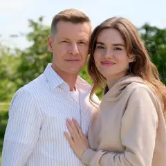 Para, która zastanawia się, ile odcinków ma M jak Miłość, pozuje na tle zieleni.