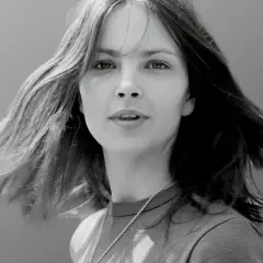 Młoda Anna Dymna, z rozwianymi włosami, w kadrze przypominającym scenę z jej wczesnych filmów.