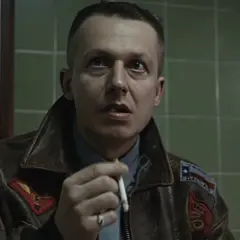Władysław Pasikowski, reżyser filmu Kroll, w skórzanej kurtce, z papierosem w dłoni.