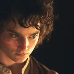 Elijah Wood, kto gra Frodo Bagginsa, z czerwonym znakiem na policzku, w ciemności.