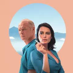 Para z filmu "La Gomera" na tle gór i nieba. Mężczyzna z siwymi włosami i kobieta z papierosem w dłoni.