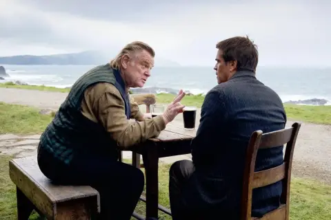 Dwóch mężczyzn przy stole, jeden gestykuluje, drugi słucha. Scena z filmu "Duchy Inisherin" - recenzja.