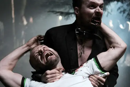 Krwawa scena z polskiego filmu o zombie. Jeden mężczyzna dusi drugiego, który krzyczy z bólu.