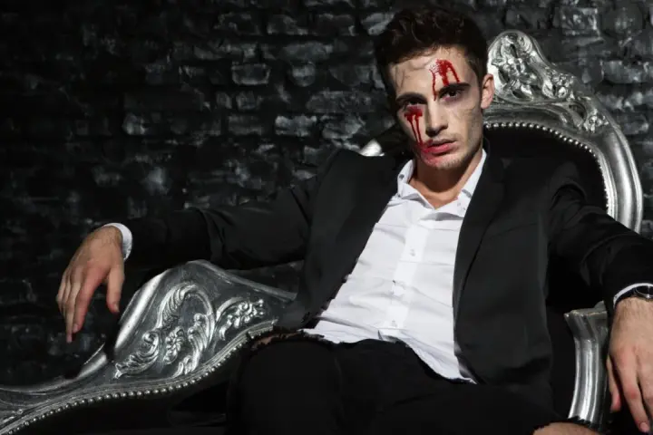 Mężczyzna w garniturze, z krwią na twarzy, siedzi na ozdobnym tronie. Czy Patrick Bateman naprawdę zabijał?