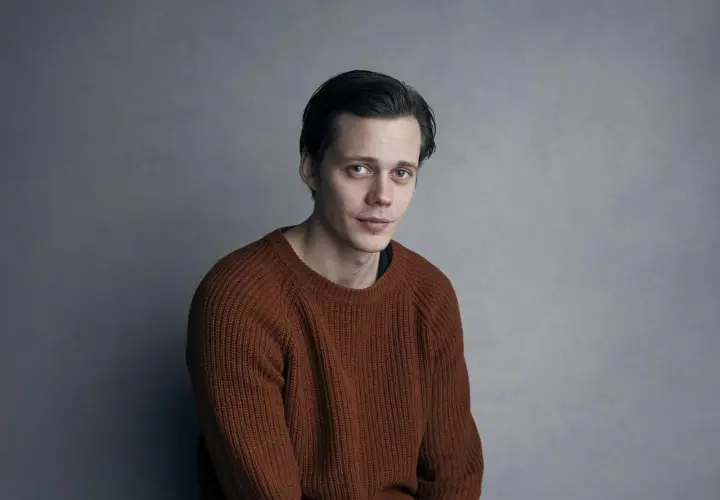 Bill Skarsgård w rudym swetrze, zastanawia się, w jakich filmach grał.