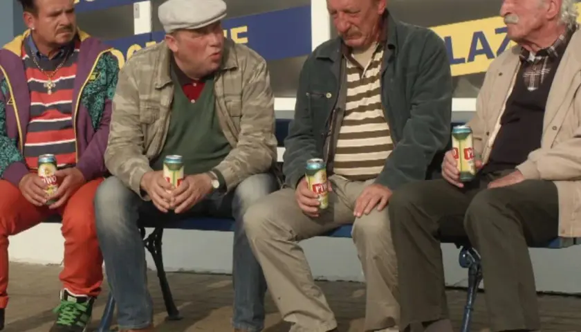 Czterech mężczyzn siedzi na ławce, pijąc piwo. Czekają na kolejne odcinki "Rancza".