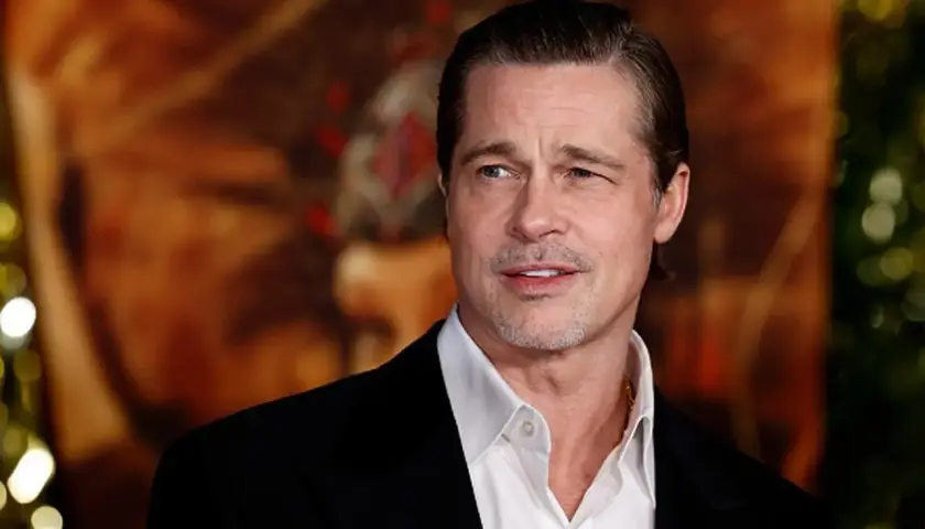 Brad Pitt w czarnym garniturze i białej koszuli, z lekkim zarostem. Wygląda jakby zastanawiał się, kiedy urodził się Brad Pitt.