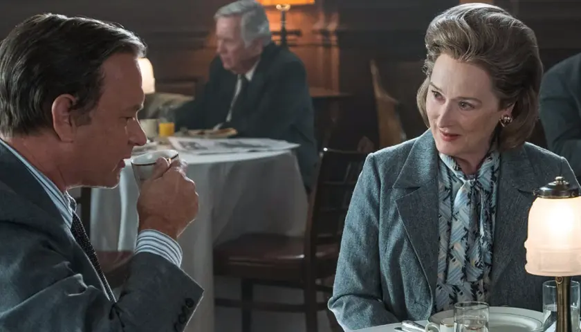 Tom Hanks i Meryl Streep w scenie z filmu "Czwarta władza", dyskutują przy stole.