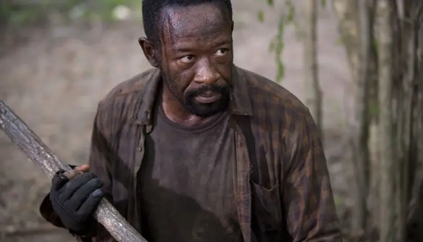 Morgan z "The Walking Dead 6" z kijem w ręku, gotowy do walki w lesie.