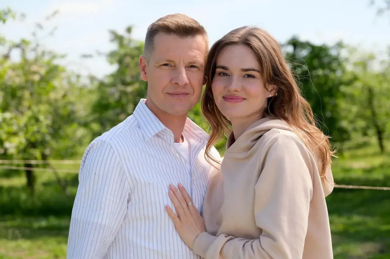 Para, która zastanawia się, ile odcinków ma M jak Miłość, pozuje na tle zieleni.