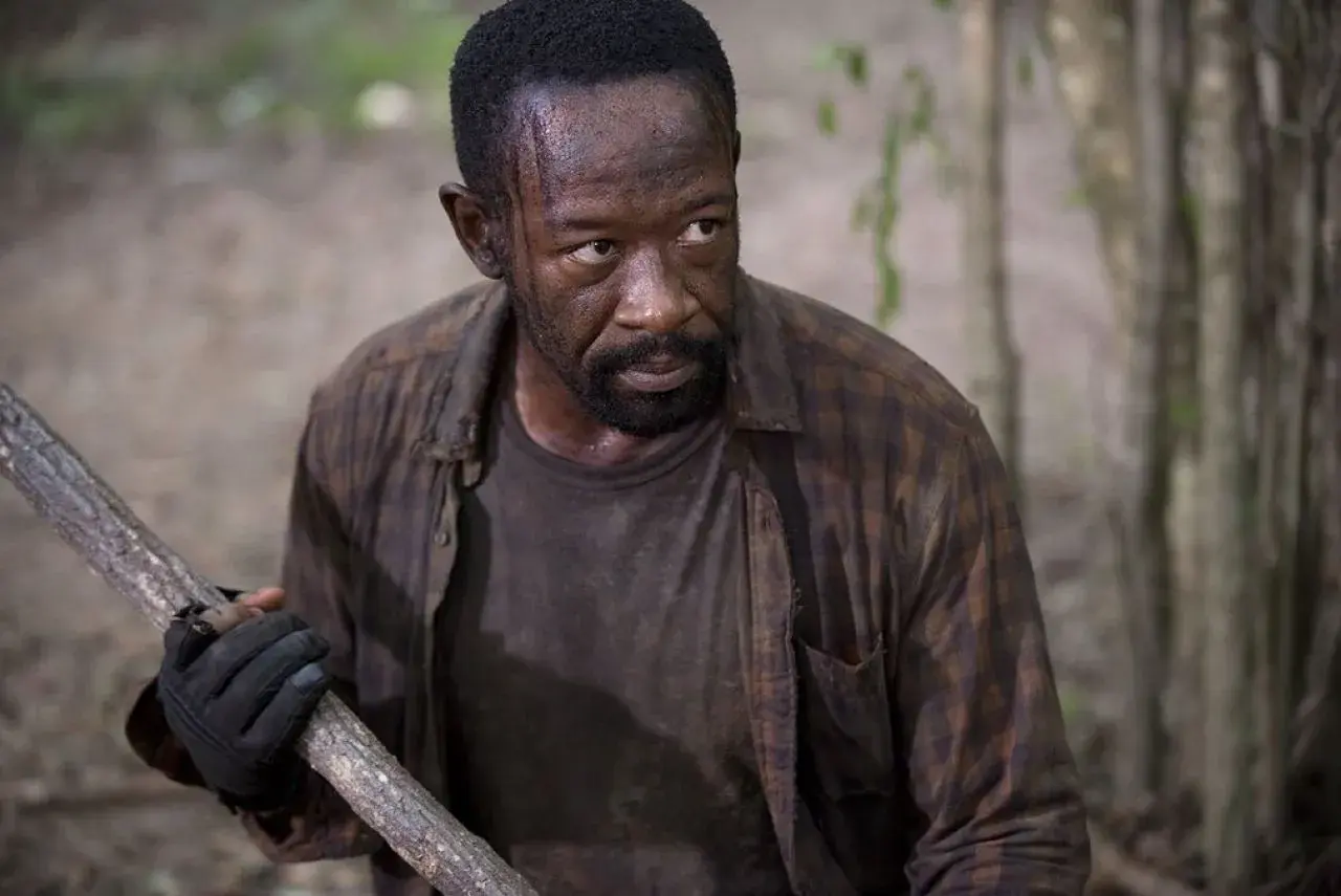Morgan z "The Walking Dead 6" z kijem w ręku, gotowy do walki w lesie.