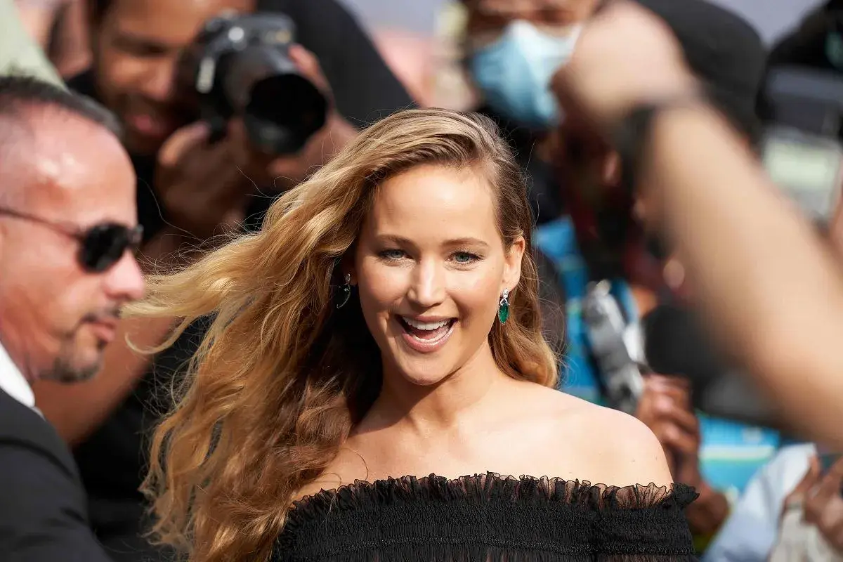 Jennifer Lawrence, uśmiechnięta, otoczona przez paparazzi. Ciekawe, ile lat ma Jennifer Lawrence, gdy robi taką karierę?