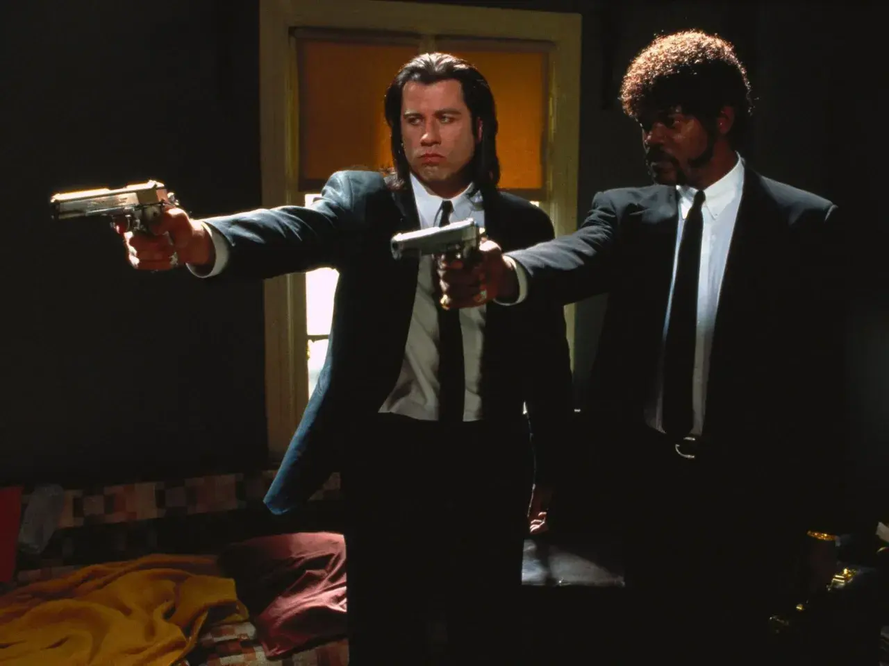 Vincent Vega i Jules Winnfield z Pulp Fiction, filmu często uznawanego za jeden z 10 najlepszych filmów wszechczasów, celują z broni.