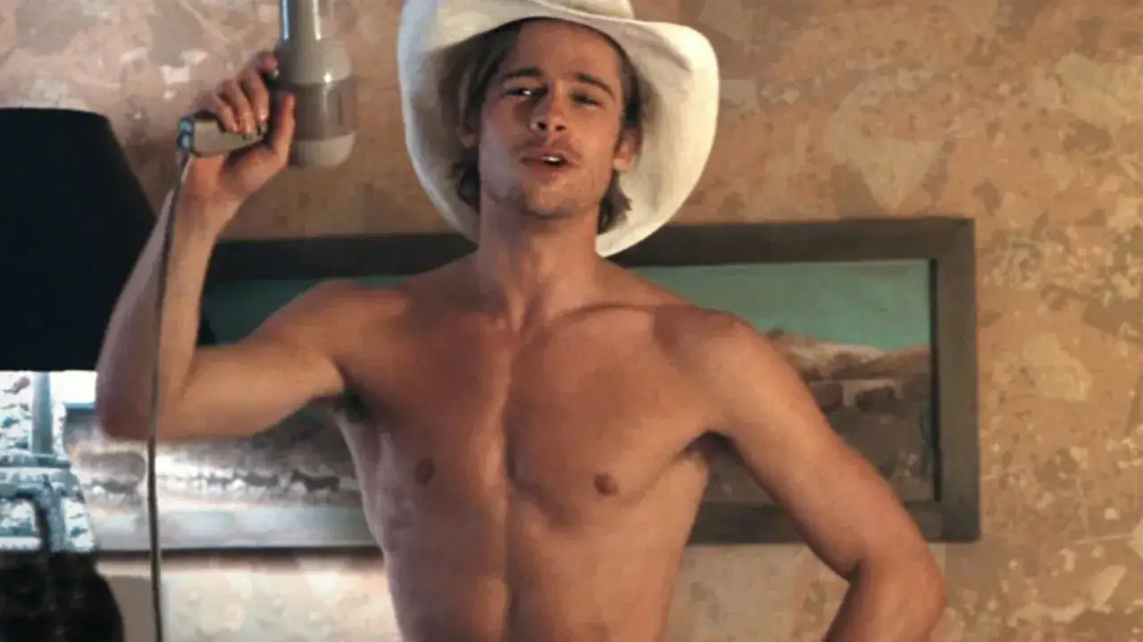 Brad Pitt w kapeluszu kowbojskim, z suszarką w ręku. Wygląda jakby właśnie się dowiedział, kiedy urodził się Brad Pitt.