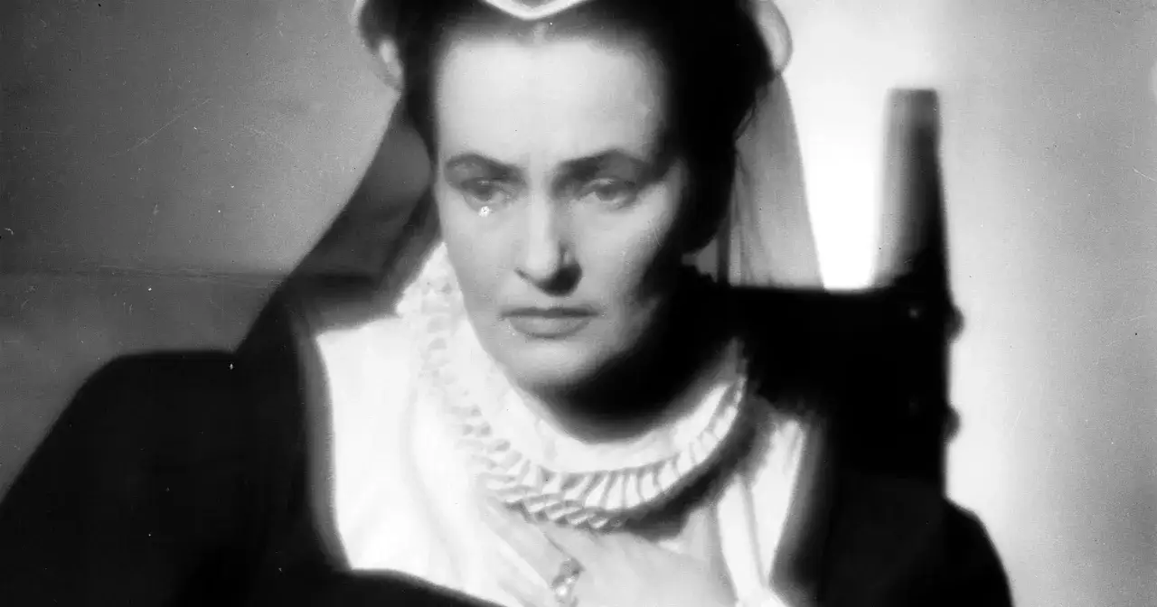 Hanna Skarżanka w filmach, z dłonią na piersi, w eleganckiej sukni z żabotem.