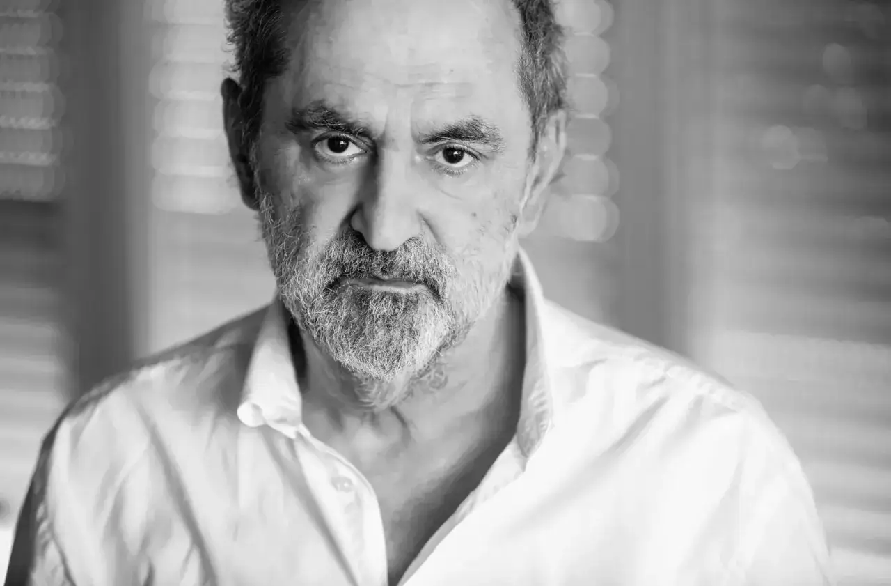 Portret mężczyzny z siwą brodą, w białej koszuli. Jego spojrzenie jest intensywne, jakby zapowiadało nowy film Piotra Szulkina.