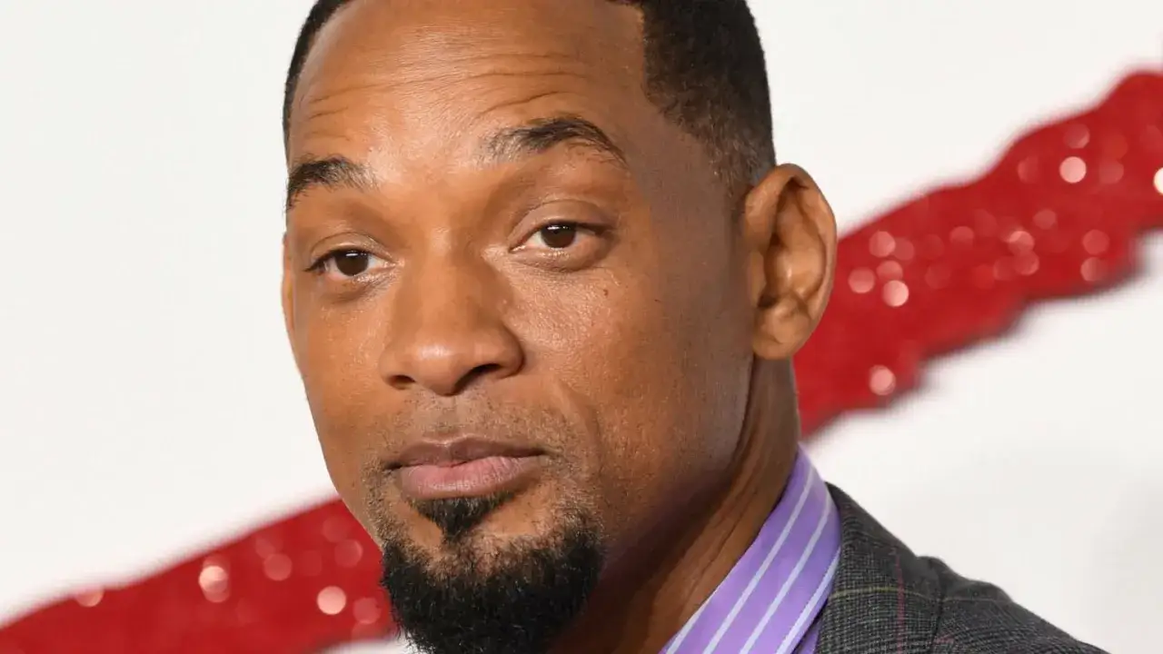 Zbliżenie na twarz Willa Smitha. Aktor ma krótko przystrzyżone włosy, zarost i nosi koszulę w fioletowo-białe paski. Zastanawiasz się, ile wzrostu ma Will Smith?