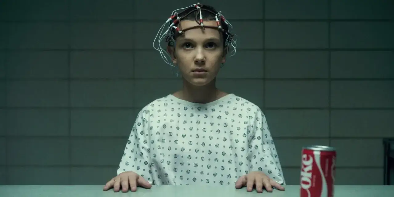Eleven w 4 sezonie ma 14 lat. Siedzi w szpitalnej koszuli z elektrodami na głowie, obok puszka Coca-Coli.