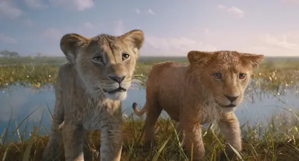 Dwa lwiątka, Simba i Nala, w realistycznej wersji Króla Lwa, stoją na tle sawanny i wody.